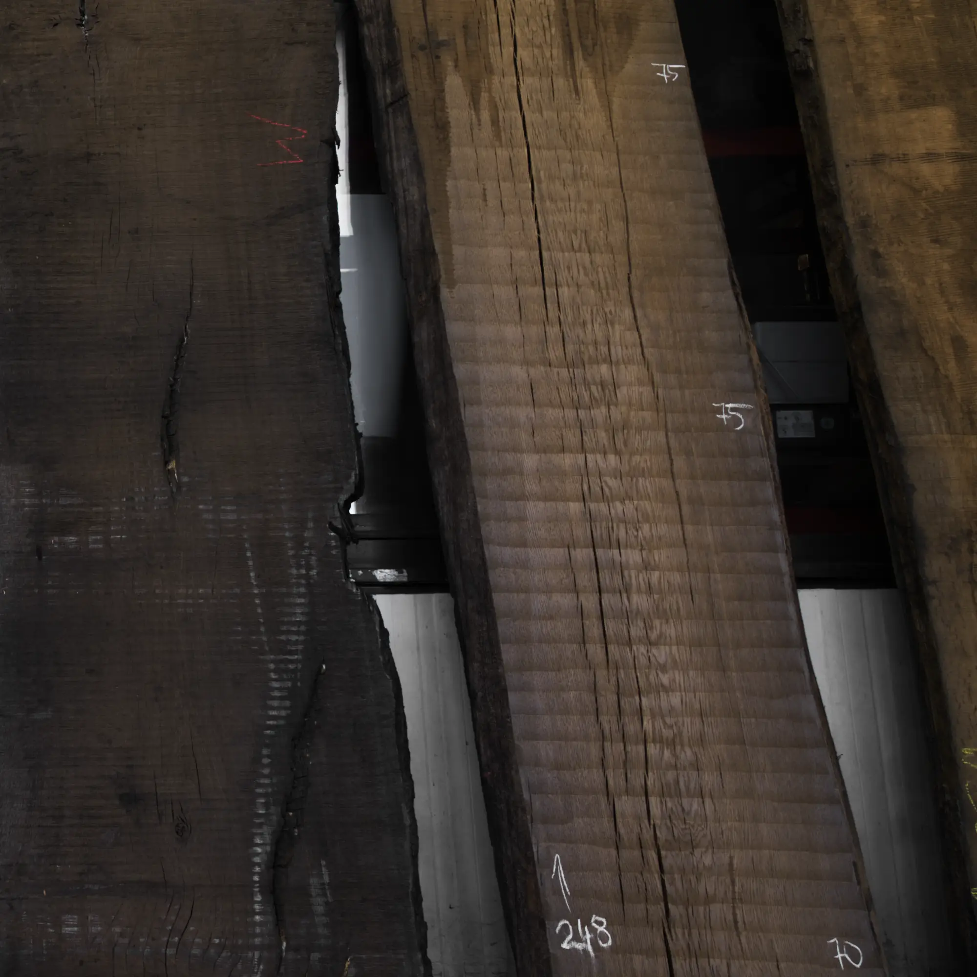 Mit Kreide beschriftete, rohe Mooreichenbretter